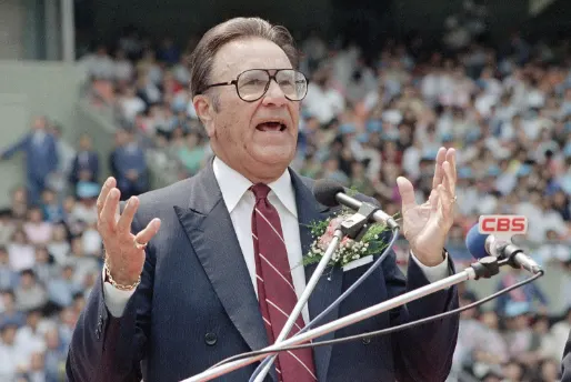 A man in suit and tie speaking at an event.