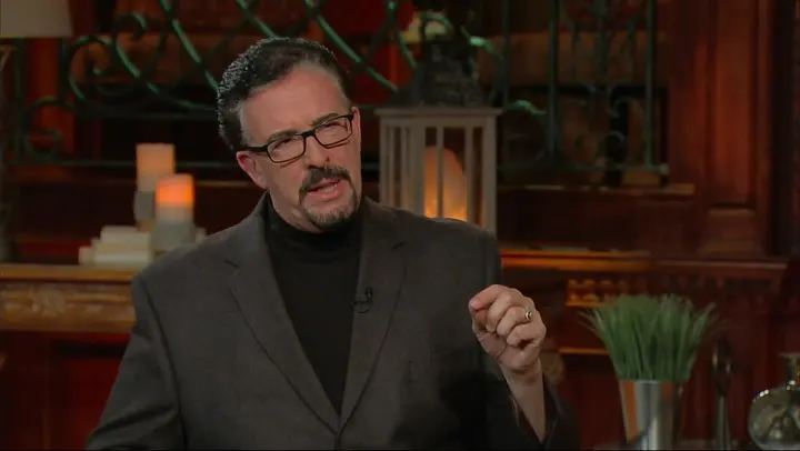 A man in glasses and a suit is talking